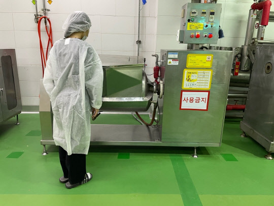 지난 17일 경기 평택시 SPL 평택공장에서 한 직원이 A씨가 작업 중 기계 안으로 상반신이 들어가는 사고를 당해 사망한 기계 옆에 있는 같은 기종의 소스 교반기를 살펴보고 있다. 연합뉴스